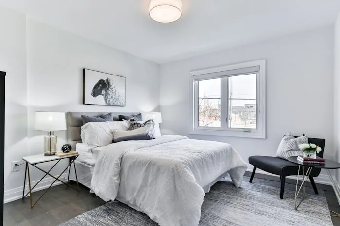 A bright, minimal bedroom with a large window.