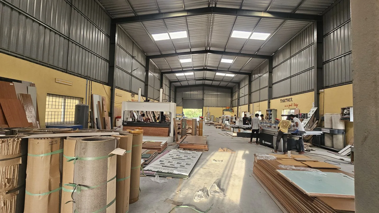 The Haus Projekt factory floor — panel stacks, machines and the long central aisle.